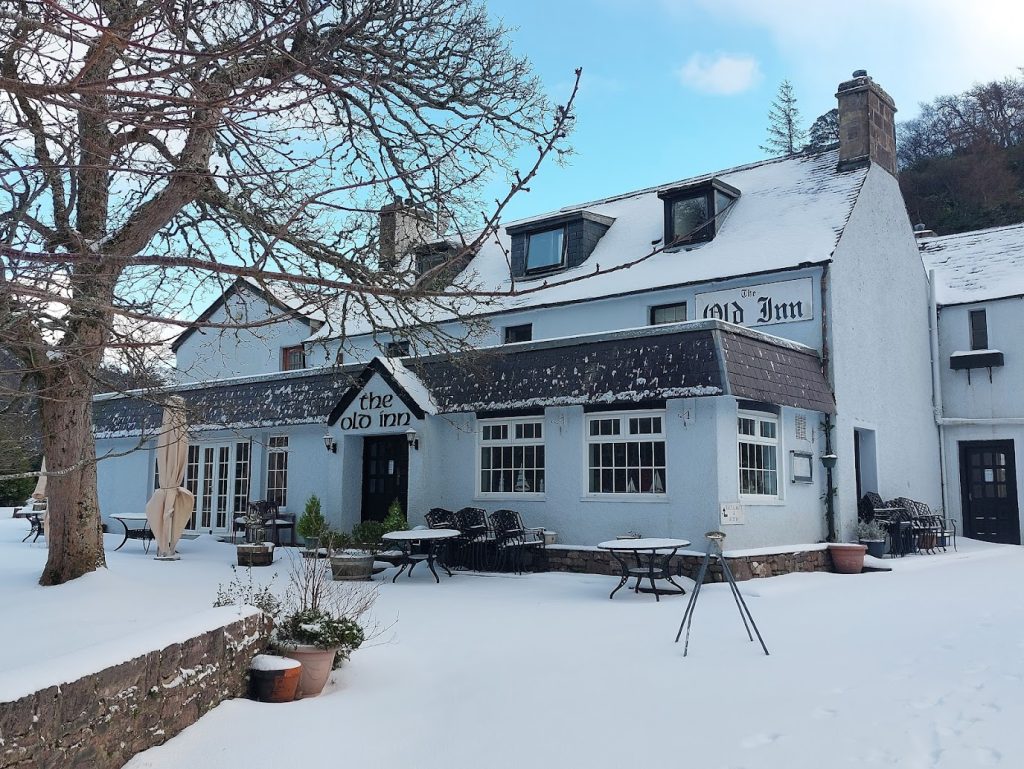 The Old Inn covered in snow during the winter months, offering a warm sanctuary for hikers and NC500 travellers.