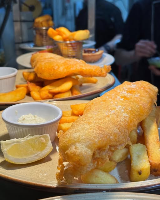 Traditional golden battered fish and chips served with tartare sauce and a lemon wedge, a popular choice at our seafood restaurant in Gairloch.