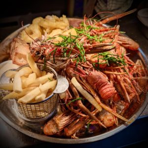 A spectacular seafood platter featuring fresh local langoustines, squat lobsters, and chips, showcasing the best seafood in Gairloch.