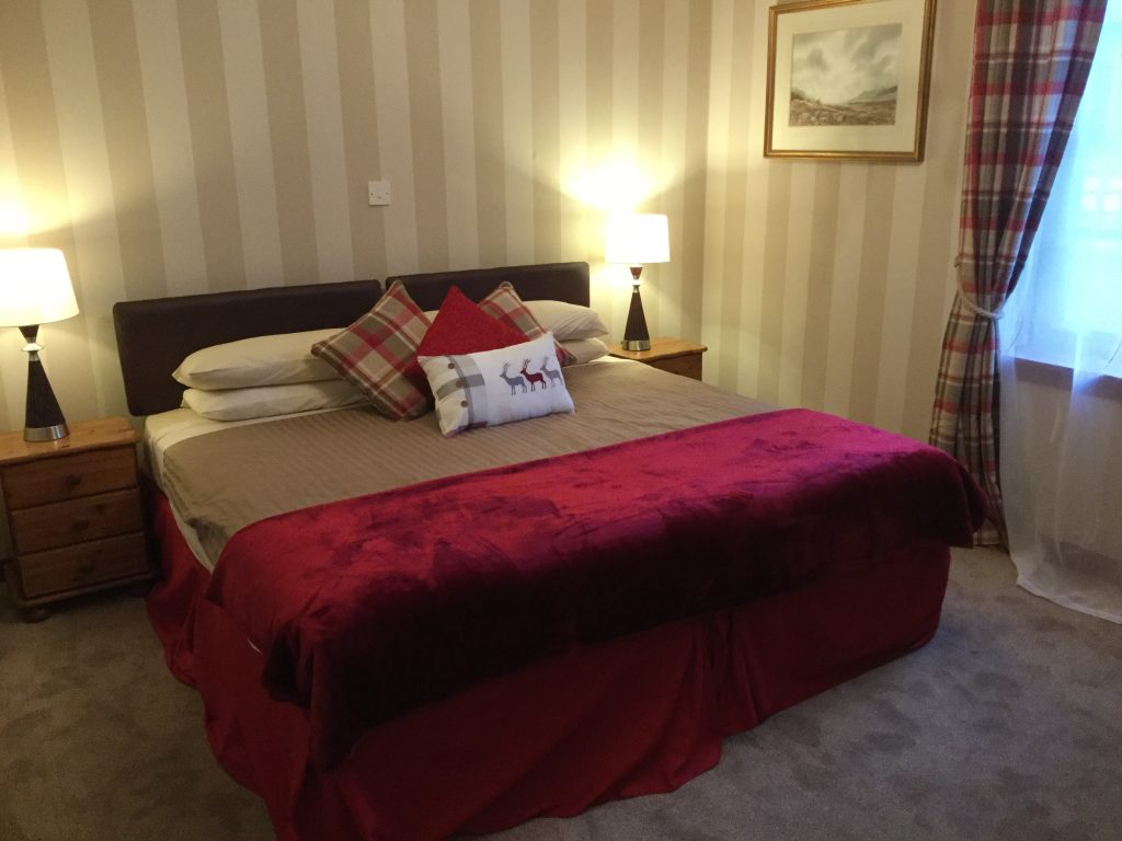 Traditional Highland twin bedroom at The Old Inn featuring stag-themed decor and comfortable bedding.