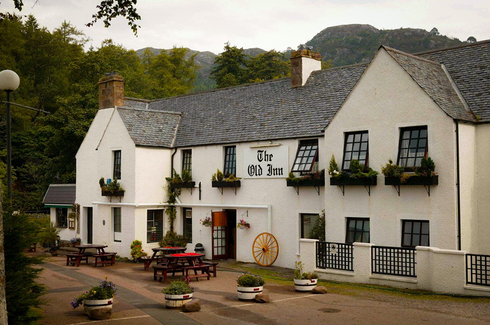 Exterior view of The Old Inn, a traditional white stone building in Flowerdale Glen, Gairloch.